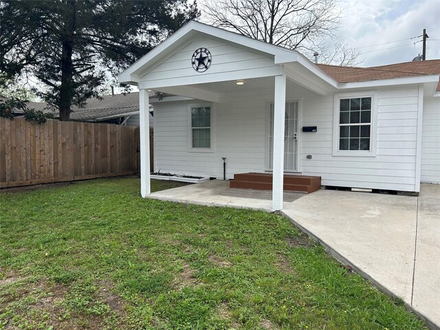 rear view of property with a yard and a patio