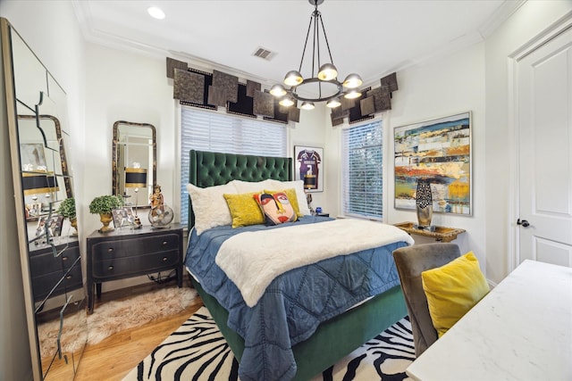 bedroom featuring a notable chandelier, light wood-type flooring, and ornamental molding