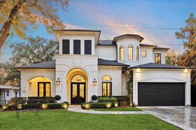 view of front of home featuring french doors, a yard, and a garage