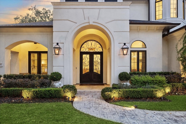 exterior entry at dusk featuring french doors