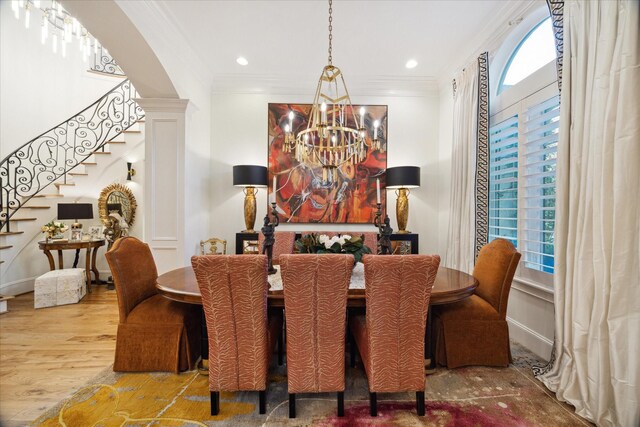 dining space with a notable chandelier, plenty of natural light, crown molding, and hardwood / wood-style floors