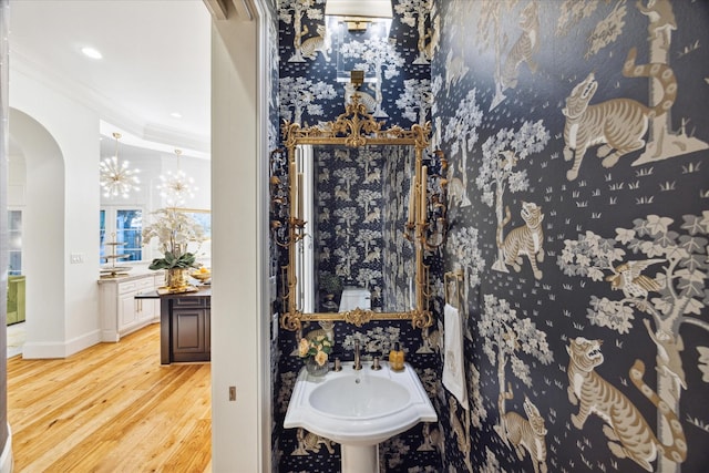 bathroom featuring hardwood / wood-style flooring, toilet, crown molding, and sink