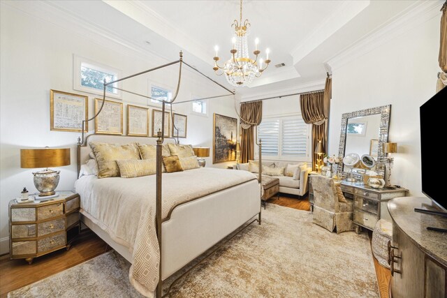 bedroom with hardwood / wood-style floors, a raised ceiling, ornamental molding, and a notable chandelier