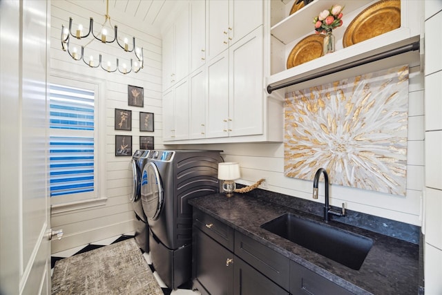 laundry area with wood walls, cabinets, sink, tile patterned flooring, and washer and dryer