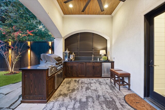 view of patio with sink, a grill, ceiling fan, and exterior kitchen