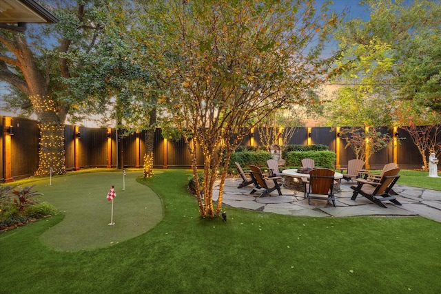 yard at dusk with a patio area and an outdoor fire pit