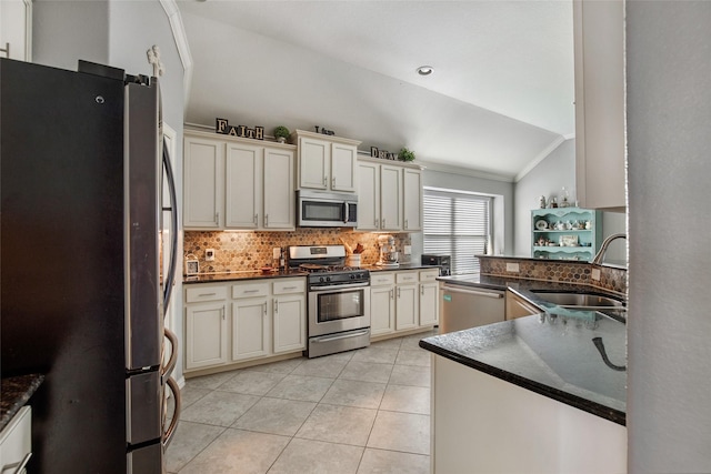 kitchen with lofted ceiling, sink, light tile patterned floors, ornamental molding, and stainless steel appliances