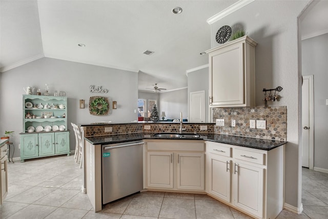 kitchen featuring cream cabinets, ceiling fan, dishwasher, and dark stone counters