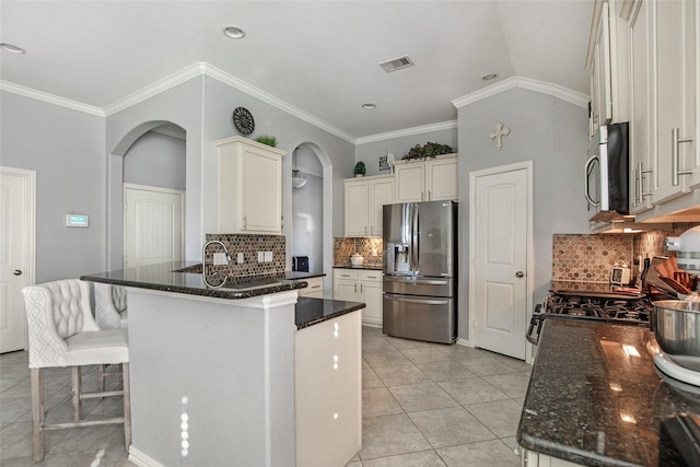 kitchen with backsplash, stainless steel fridge with ice dispenser, light tile patterned floors, and vaulted ceiling