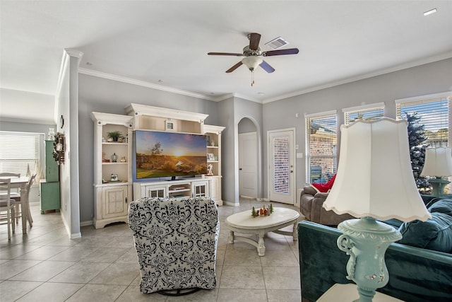 tiled living room with ceiling fan and crown molding