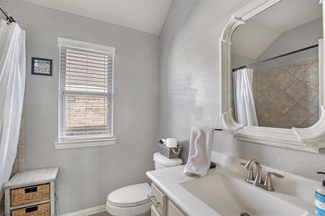 bathroom featuring vanity, toilet, and lofted ceiling