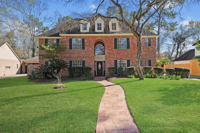 colonial-style house featuring a front lawn