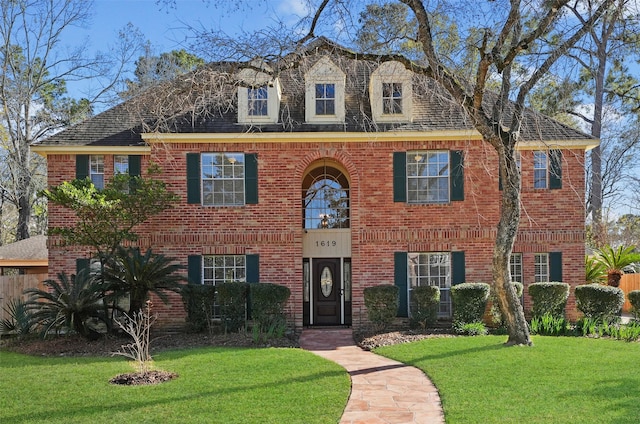 colonial inspired home featuring a front lawn