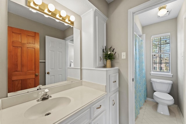 bathroom with toilet, vanity, and tile patterned floors