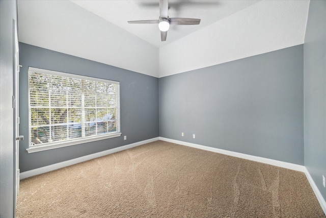 carpeted spare room featuring lofted ceiling and ceiling fan