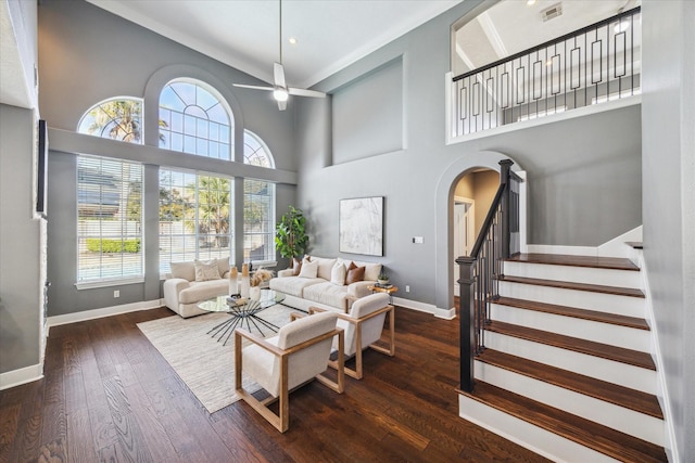 living room featuring ceiling fan, a towering ceiling, and dark hardwood / wood-style flooring