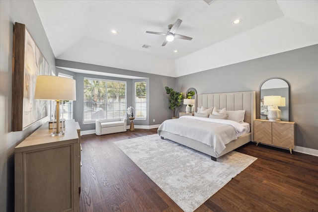 bedroom featuring dark hardwood / wood-style floors, ceiling fan, a tray ceiling, and vaulted ceiling