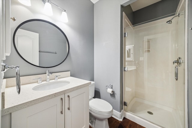 bathroom featuring vanity, toilet, an enclosed shower, and hardwood / wood-style floors