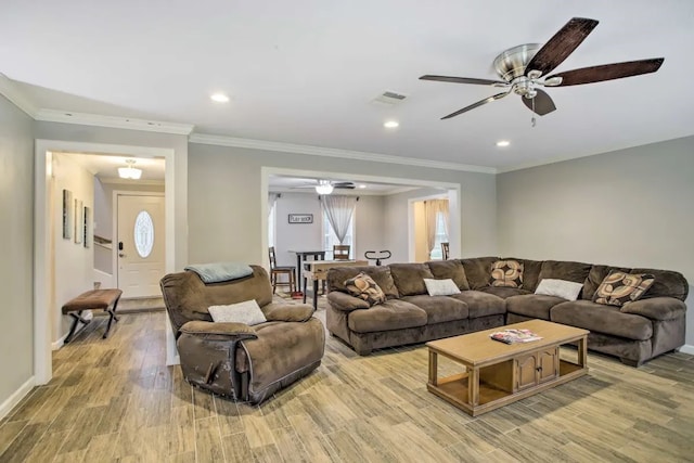 living room featuring wood-type flooring, ceiling fan, and crown molding