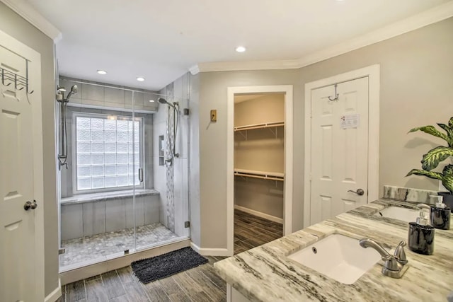 bathroom with a shower with door, vanity, and ornamental molding