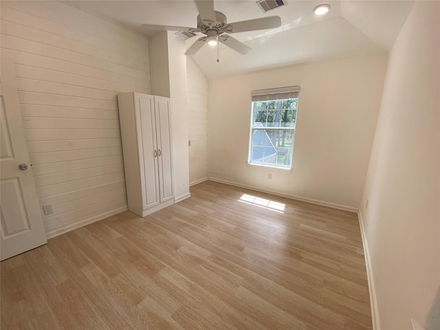 spare room with ceiling fan, light hardwood / wood-style floors, and vaulted ceiling