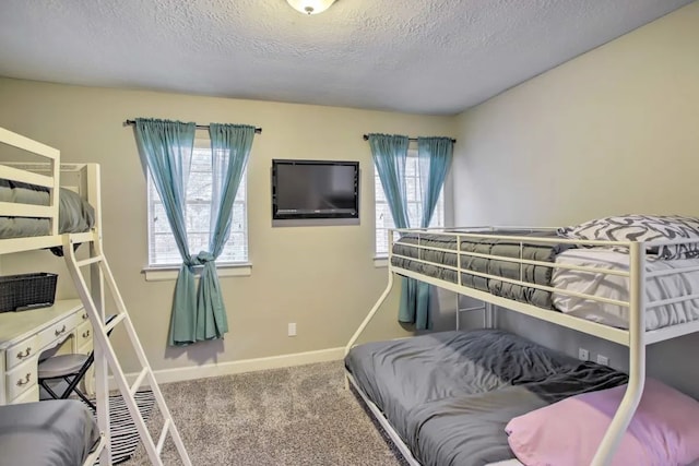 carpeted bedroom with a textured ceiling and multiple windows