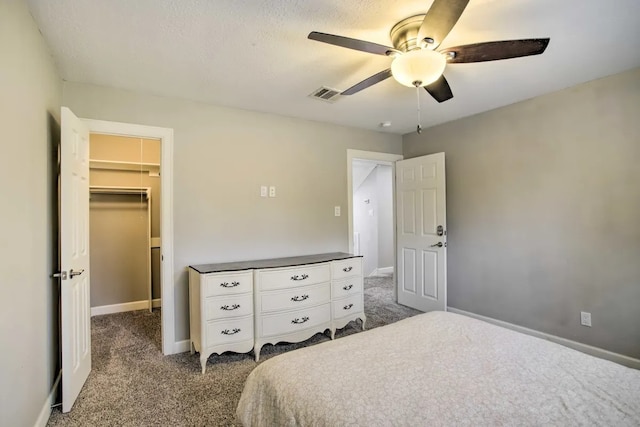 carpeted bedroom with ceiling fan, a spacious closet, and a closet