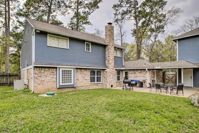 back of property featuring a patio area and a lawn