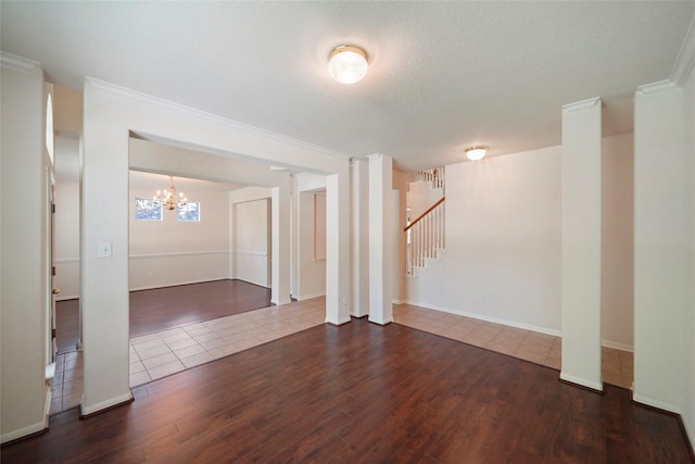 unfurnished room with crown molding, dark wood-type flooring, and a chandelier