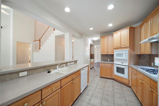 kitchen with backsplash, sink, light tile patterned flooring, and white appliances