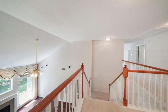 stairway featuring ceiling fan and vaulted ceiling