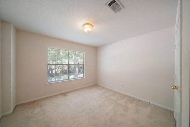 carpeted spare room featuring a textured ceiling