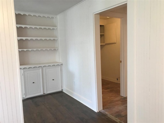 interior space featuring wood walls, dark hardwood / wood-style flooring, and crown molding