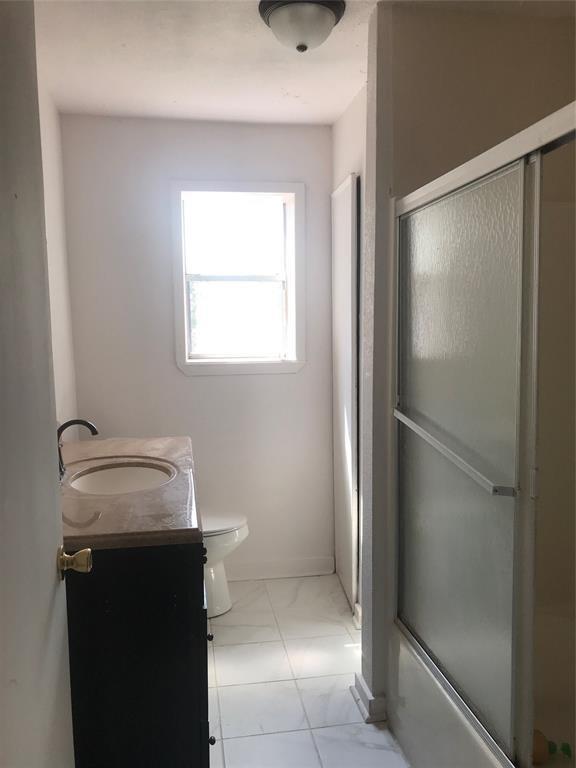 full bathroom featuring vanity, toilet, and enclosed tub / shower combo