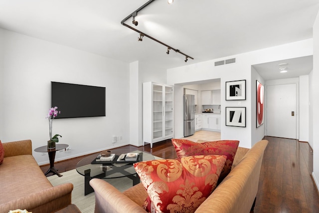 living room with wood-type flooring and rail lighting