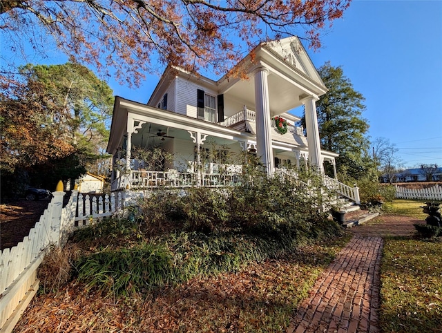 view of front of house with covered porch, ceiling fan, and a balcony