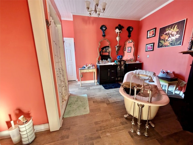 interior space with vanity, ornamental molding, a tub, and an inviting chandelier