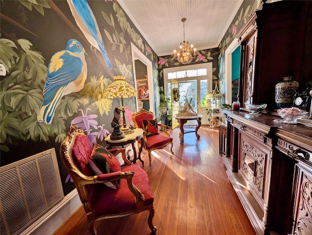 interior space featuring a notable chandelier, wood-type flooring, and ornamental molding