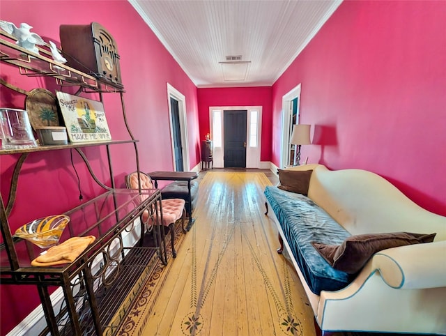 sitting room with wood-type flooring and ornamental molding