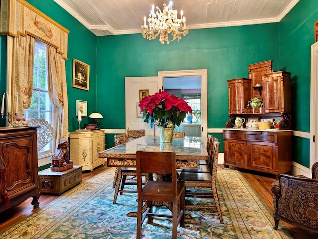 dining room with light wood-type flooring, an inviting chandelier, plenty of natural light, and crown molding