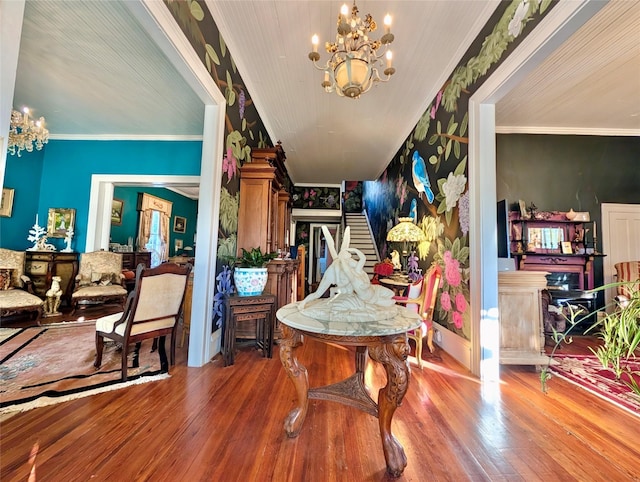 entryway with a chandelier, wood-type flooring, and ornamental molding