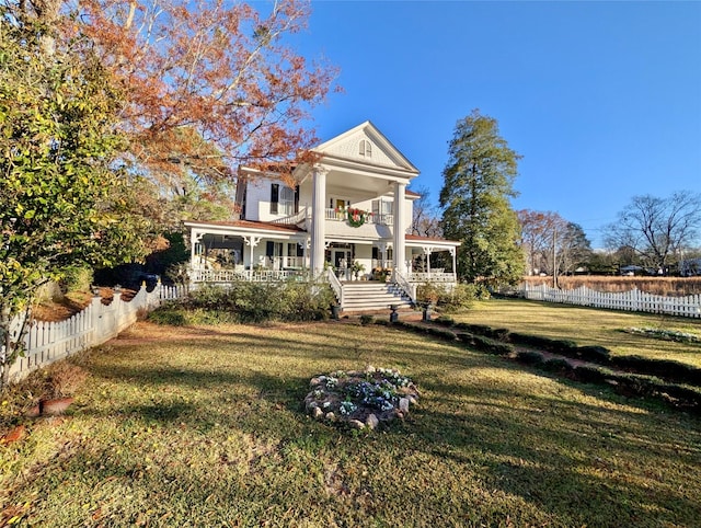 view of front of house featuring a front yard, a porch, and a balcony