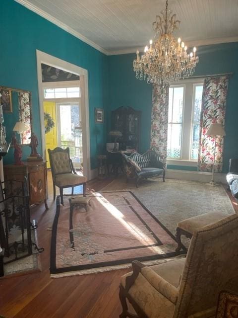 living area featuring crown molding, hardwood / wood-style floors, and a notable chandelier