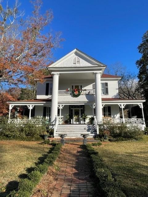 back of property featuring covered porch and a yard