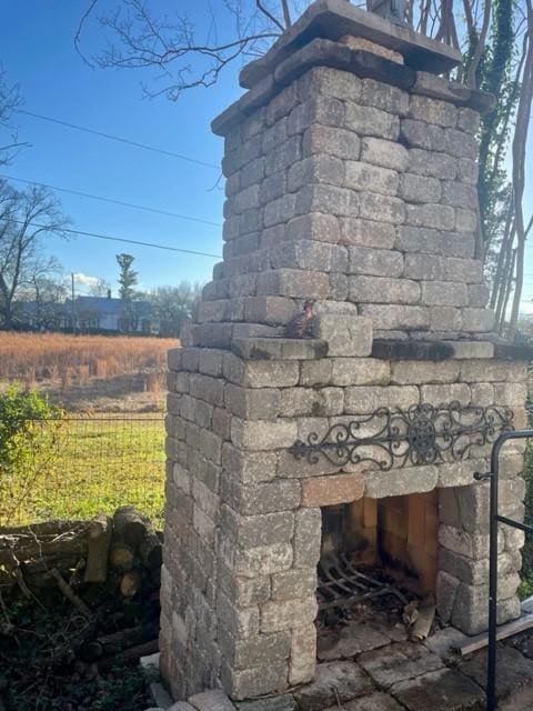 exterior details featuring an outdoor stone fireplace