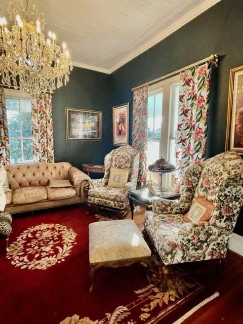 sitting room featuring hardwood / wood-style floors, crown molding, and a chandelier