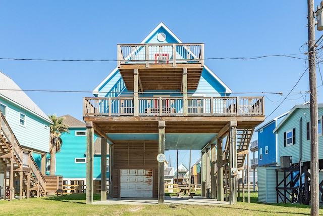 coastal inspired home featuring a front yard, a carport, a balcony, a wooden deck, and central AC