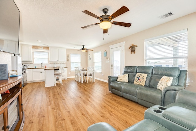 living room featuring light hardwood / wood-style floors and ceiling fan