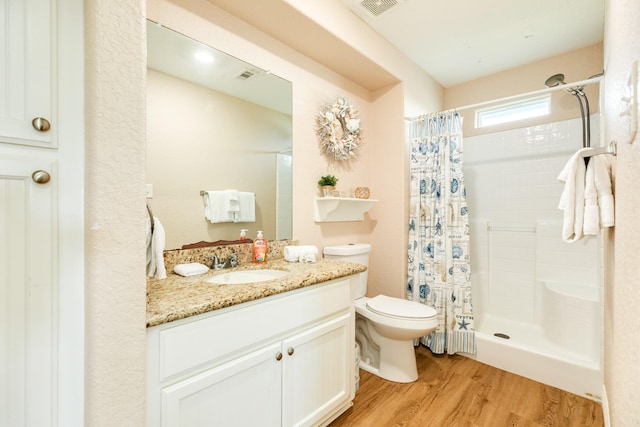 bathroom featuring toilet, hardwood / wood-style floors, vanity, and walk in shower