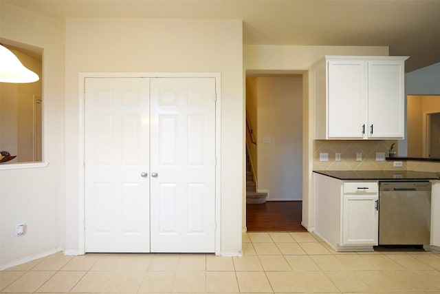 kitchen featuring dishwasher, light tile patterned flooring, white cabinets, and backsplash